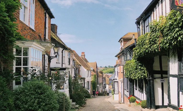 Historic cobblestone street with traditional half-timbered English houses