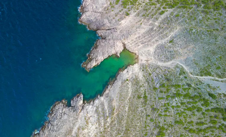 Aerial view of rocky coastline and turquoise water in Croatia