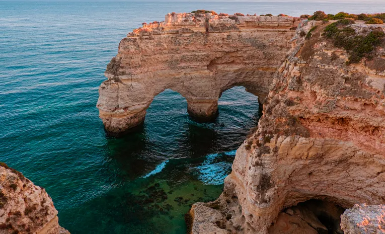Dramatic golden cliffs along the Algarve coastline in Portugal at sunset