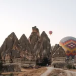 Colourful hot air balloons floating over Cappadocia's rock formations at sunrise