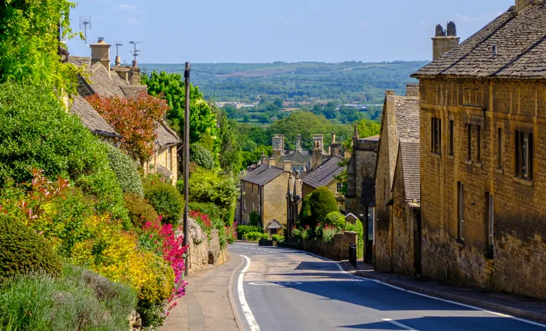 Picturesque Cotswold village street with stone houses in England