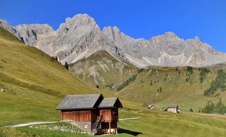 Traditional chalets set against the Dolomites mountains in Italy
