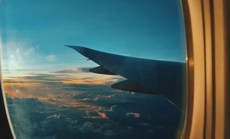 Dramatic sunset view through an airplane window during a long-haul flight